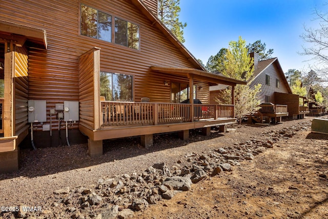 4186 Stone Pine Dr, Pinetop, AZ 85935 - rear view of property featuring a deck, faux log siding, and a chimney