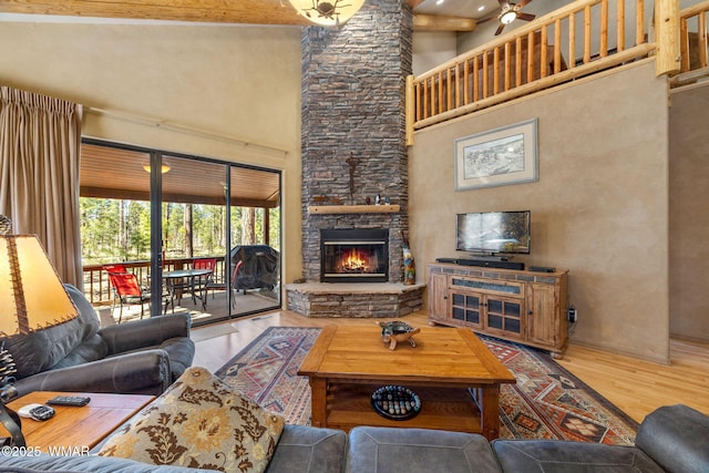 4186 Stone Pine Dr, Pinetop, AZ 85935 - living area featuring wood finished floors, a high ceiling, a stone fireplace, and ceiling fan