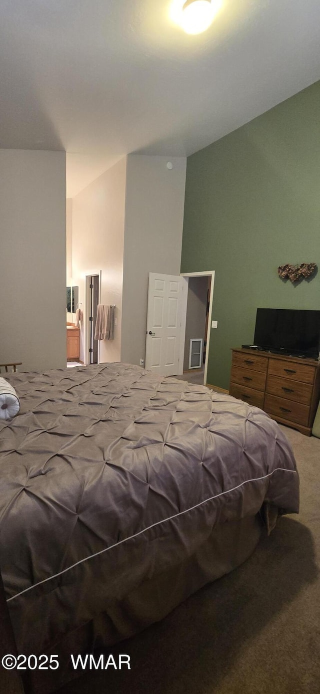 carpeted bedroom featuring vaulted ceiling and visible vents