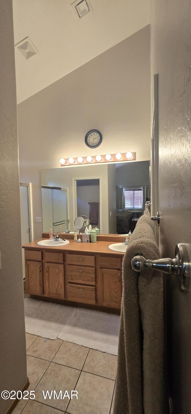 bathroom featuring double vanity, visible vents, connected bathroom, tile patterned flooring, and a sink