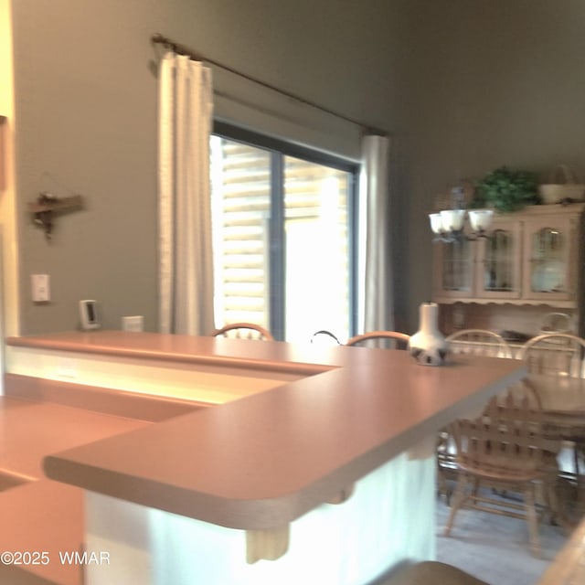 kitchen with a kitchen bar and glass insert cabinets