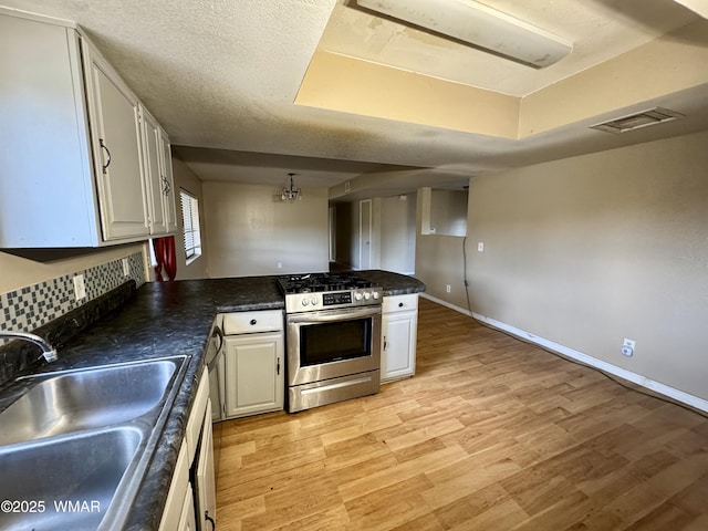 7124 Simons Way, Show Low, AZ 85901 - kitchen with stainless steel range with gas cooktop, a peninsula, light wood-style floors, and dark countertops