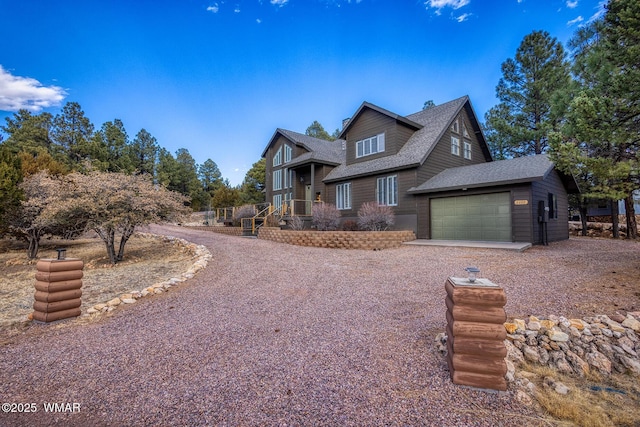 rustic home with a garage, driveway, and roof with shingles