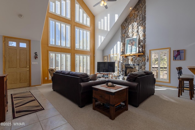 living room featuring light tile patterned floors, light colored carpet, baseboards, and ceiling fan