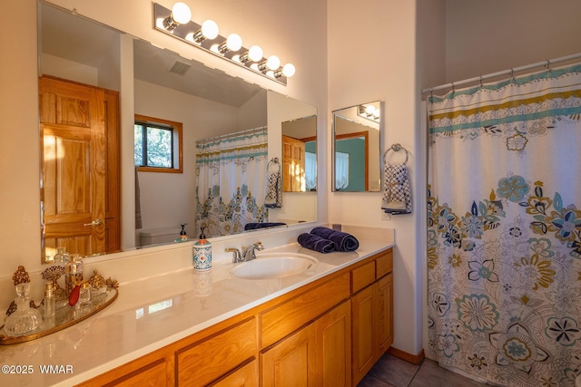 bathroom featuring tile patterned floors, visible vents, toilet, and vanity