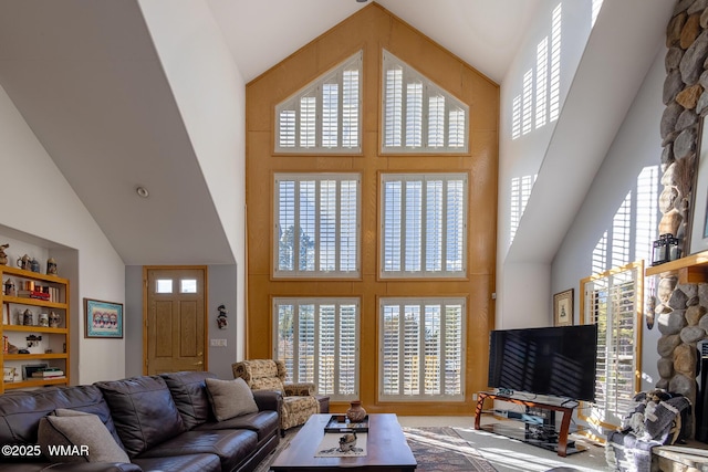 living room with high vaulted ceiling and a healthy amount of sunlight