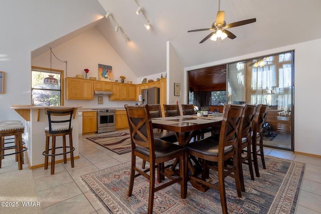 dining room featuring light tile patterned floors, a ceiling fan, baseboards, high vaulted ceiling, and rail lighting