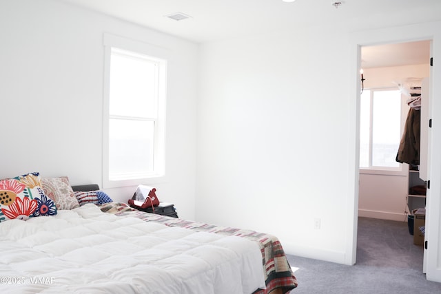 carpeted bedroom with visible vents and baseboards