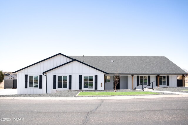 modern inspired farmhouse with a shingled roof and board and batten siding