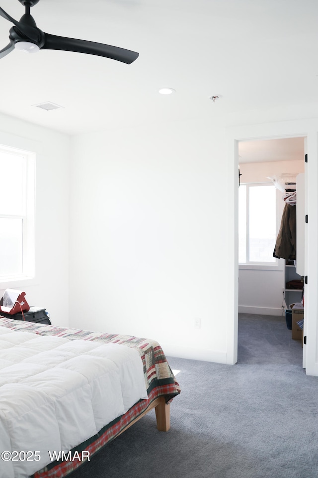 carpeted bedroom with ceiling fan, visible vents, and baseboards