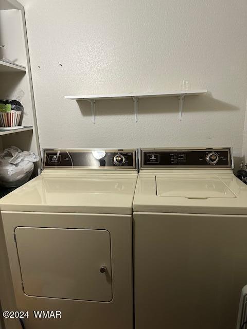 clothes washing area featuring laundry area and washer and clothes dryer