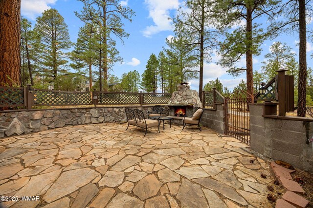 2353 Florian Meadow Trl, Overgaard, AZ 85933 - view of patio / terrace featuring an outdoor stone fireplace and a gate