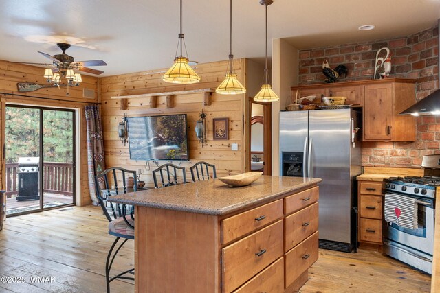 2353 Florian Meadow Trl, Overgaard, AZ 85933 - kitchen with stainless steel appliances, light wood-style floors, ceiling fan, a center island, and wood walls