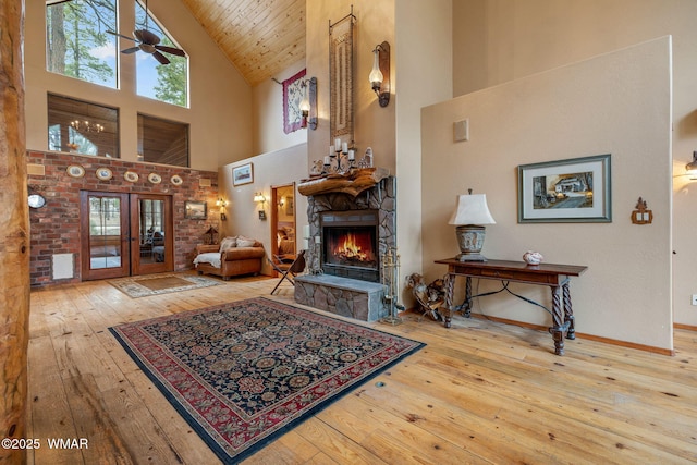 2353 Florian Meadow Trl, Overgaard, AZ 85933 - living room with high vaulted ceiling, hardwood / wood-style flooring, a fireplace, a ceiling fan, and plenty of natural light