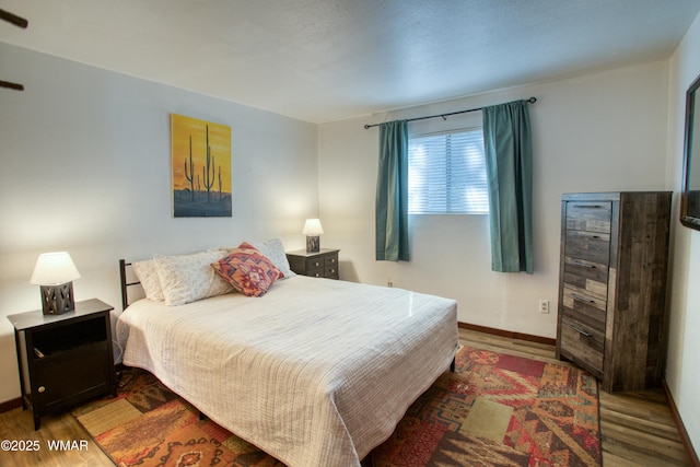 bedroom featuring baseboards and wood finished floors