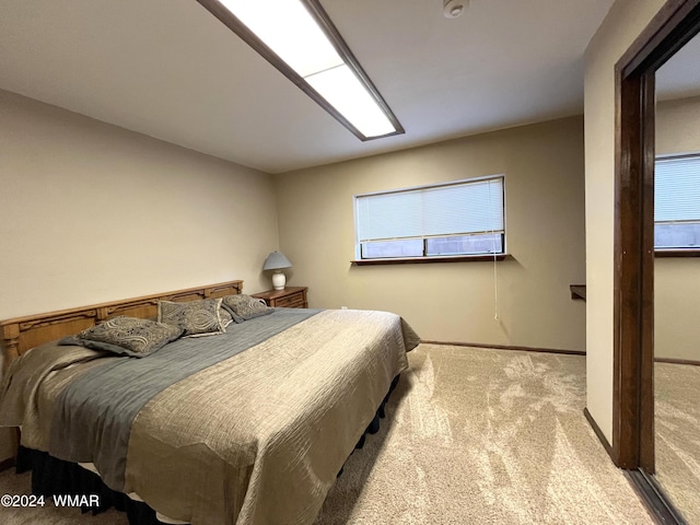 bedroom featuring light carpet and baseboards