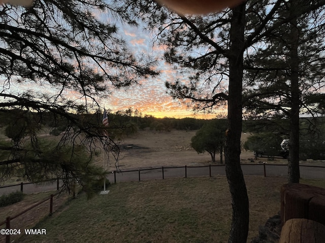 yard at dusk featuring fence