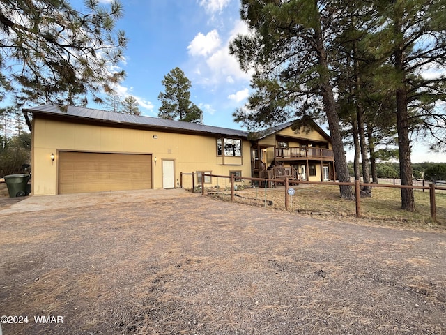 view of front of house with fence, a deck, a garage, driveway, and stairs