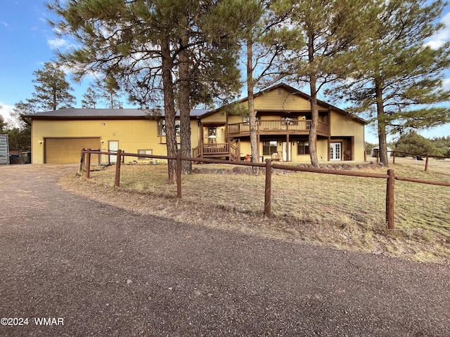 view of front of property with an attached garage, fence, and a deck