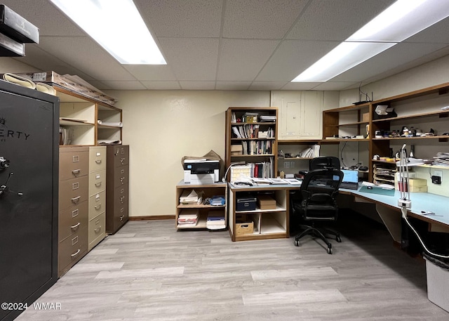 office with baseboards, a drop ceiling, and light wood finished floors