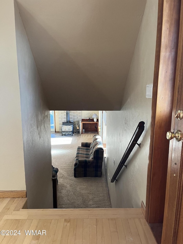 staircase with a wood stove and a textured wall