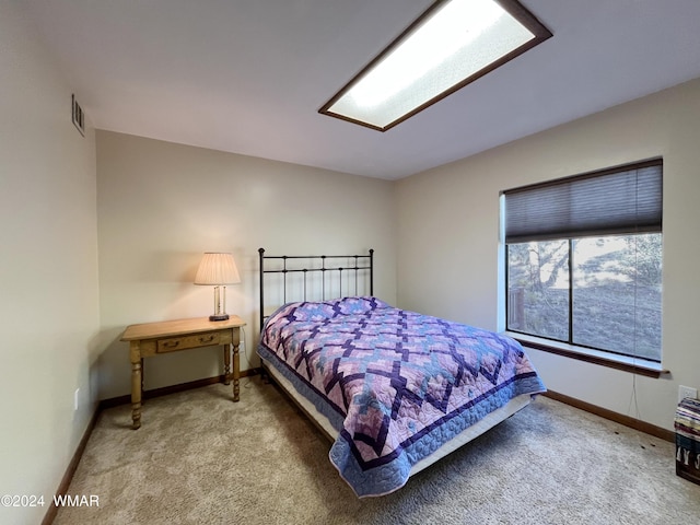 bedroom featuring carpet floors, visible vents, and baseboards