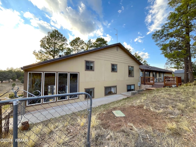 back of house featuring fence and a wooden deck