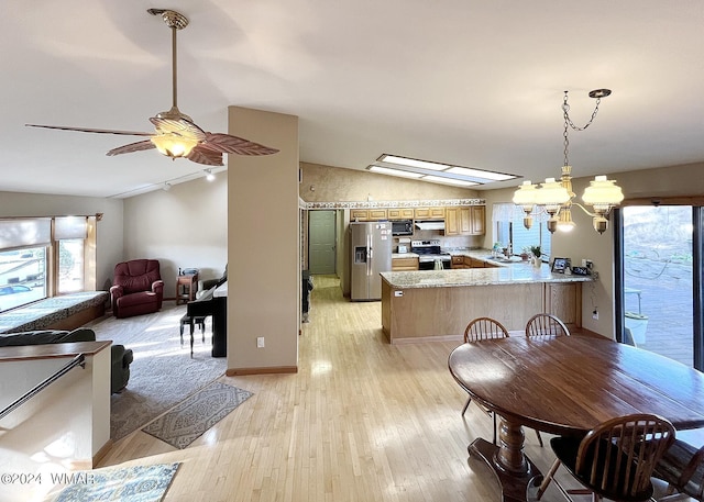 dining space featuring lofted ceiling, light wood-style flooring, and ceiling fan with notable chandelier