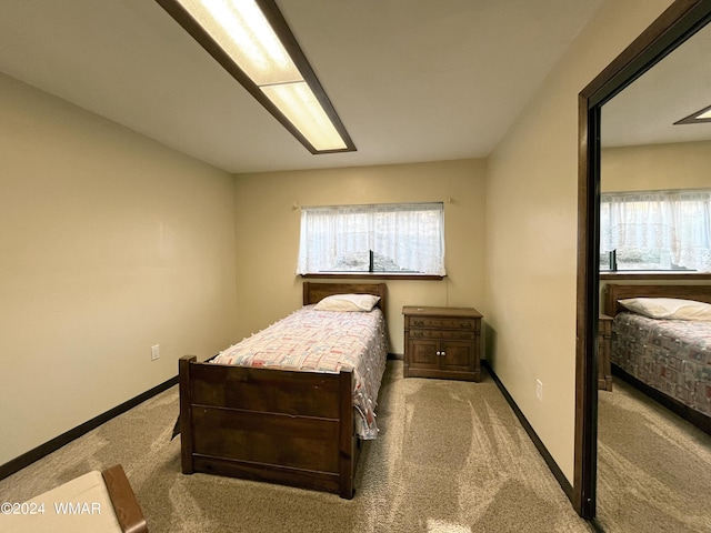 bedroom featuring baseboards, multiple windows, and light colored carpet