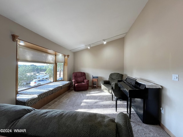 living room with light carpet, rail lighting, baseboards, and lofted ceiling