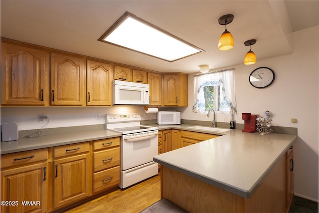 839 S 3rd St, Snowflake, AZ 85937 - kitchen featuring white appliances, a sink, a peninsula, light wood-style floors, and pendant lighting