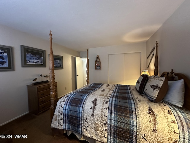 bedroom with dark colored carpet, a closet, and baseboards