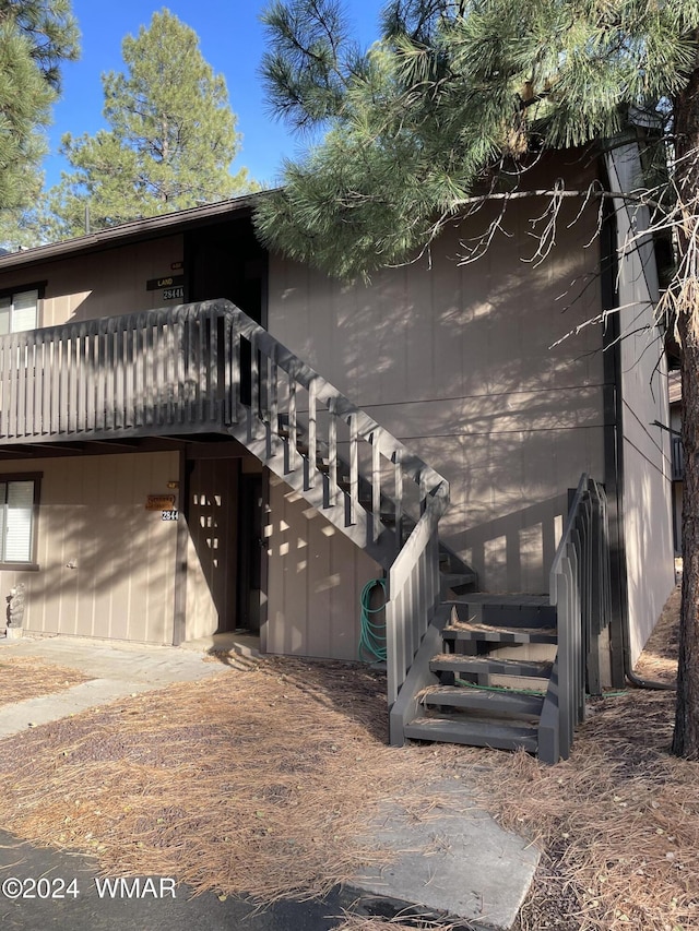 view of property exterior featuring a deck and stairs