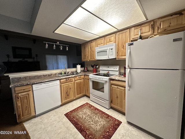 kitchen featuring dark countertops, white appliances, brown cabinets, and a sink