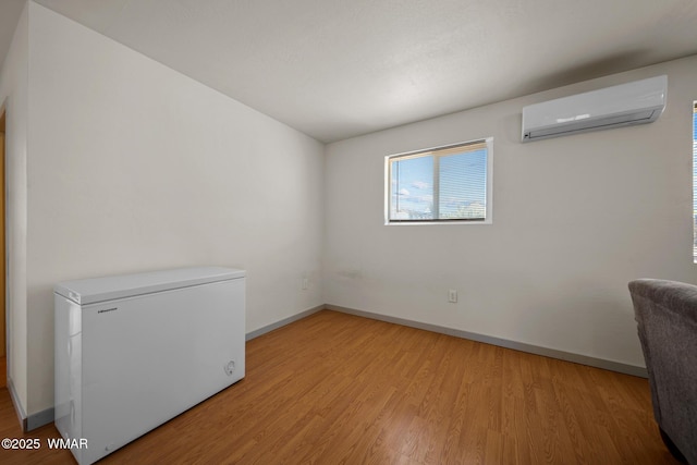 202 700th St W, Taylor, AZ 85939 - unfurnished room featuring a wall unit AC, light wood-style flooring, and baseboards
