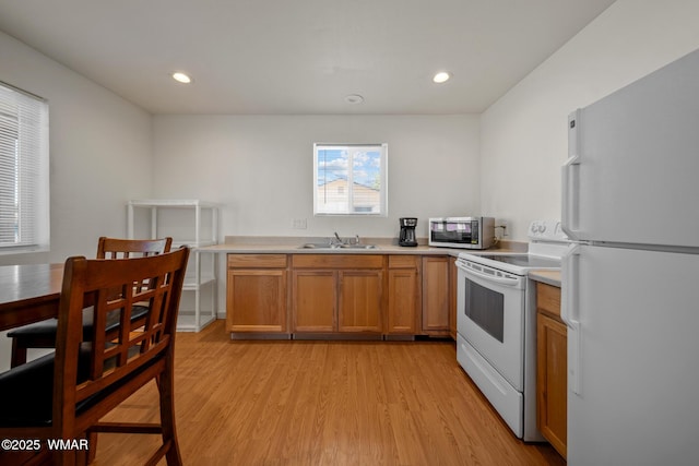 202 700th St W, Taylor, AZ 85939 - kitchen featuring white appliances, a sink, light wood-type flooring, light countertops, and brown cabinets