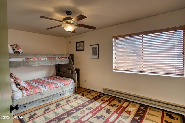 bedroom with baseboards, baseboard heating, and a ceiling fan