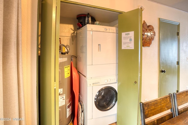 clothes washing area featuring stacked washer / drying machine, laundry area, and electric water heater