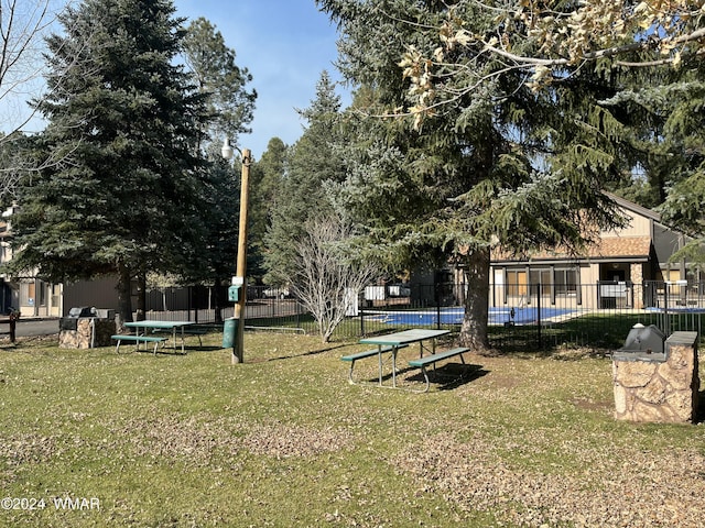 view of home's community featuring a trampoline, a lawn, and fence