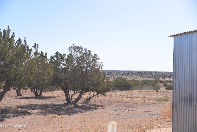 view of yard with fence and a rural view