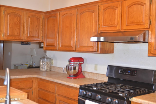 kitchen with backsplash, brown cabinets, light countertops, stainless steel range with gas cooktop, and under cabinet range hood