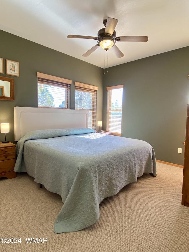 carpeted bedroom featuring baseboards and a ceiling fan