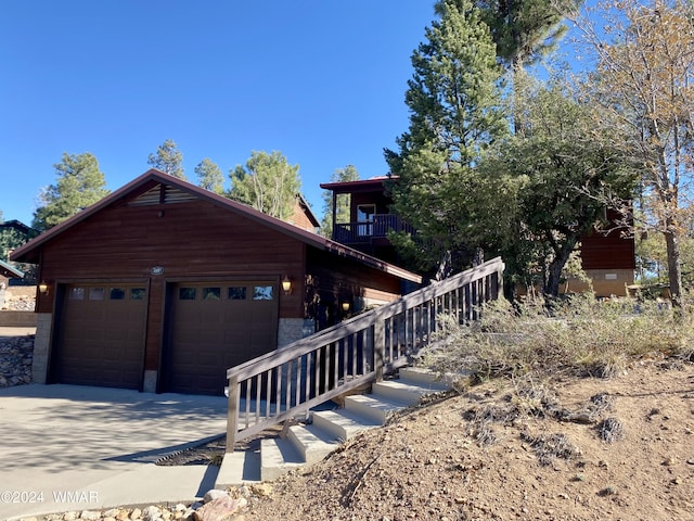 view of front of home with a garage, concrete driveway, and an outdoor structure