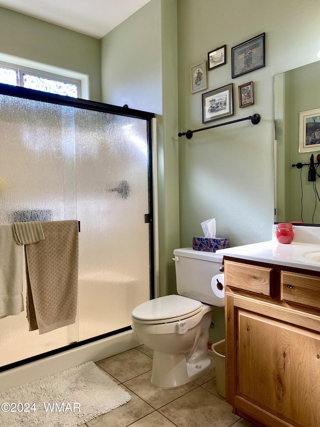 bathroom featuring a stall shower, tile patterned flooring, vanity, and toilet