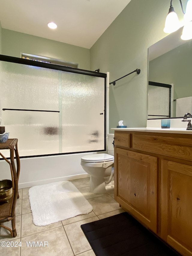 full bath with tile patterned floors, vanity, toilet, and bath / shower combo with glass door