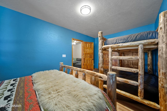 746 Jacks Wild Rd, Show Low, AZ 85901 - bedroom featuring a textured ceiling and wood finished floors