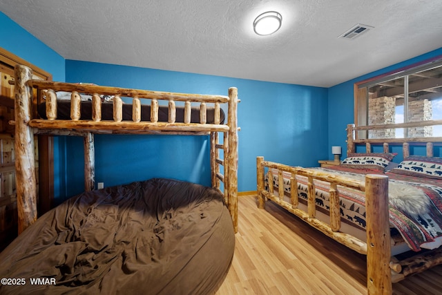 746 Jacks Wild Rd, Show Low, AZ 85901 - bedroom with a textured ceiling, visible vents, and wood finished floors