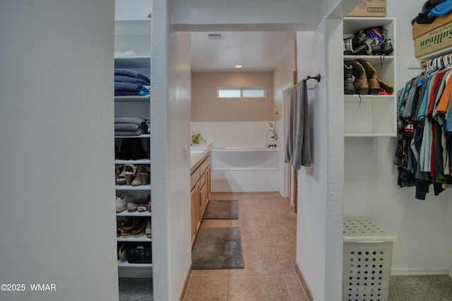 545 S 7th St, Snowflake, AZ 85937 - bathroom with a garden tub, a walk in closet, vanity, and tile patterned flooring