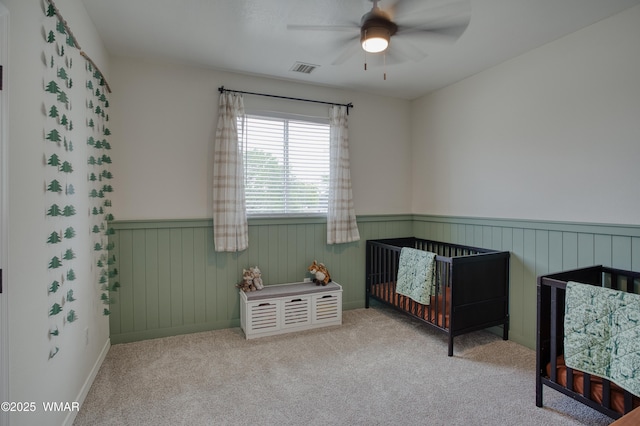 545 S 7th St, Snowflake, AZ 85937 - bedroom with wainscoting, carpet flooring, a ceiling fan, and a nursery area