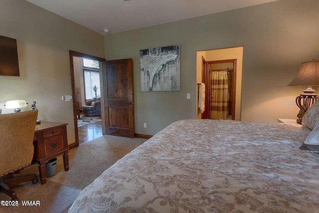 bedroom featuring light carpet and baseboards